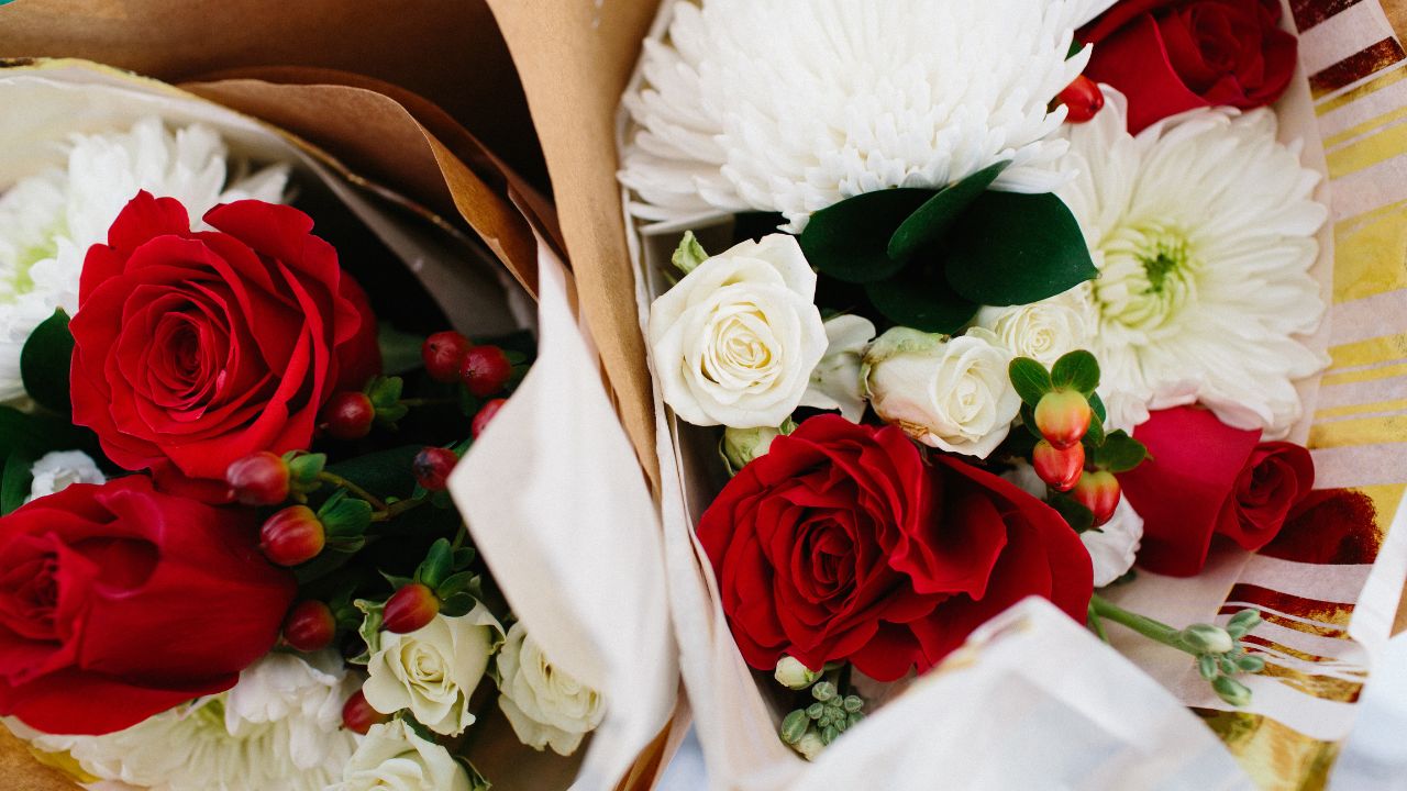 Beautiful holiday bouquet with red roses, greenery, and seasonal winter flowers - available at Biltmore Park's 2025 Holiday Market.