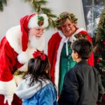 Two children meeting Santa Claus and Mrs. Claus at Biltmore Park's Santa in the Square event, one of many things to do in Asheville this holiday.