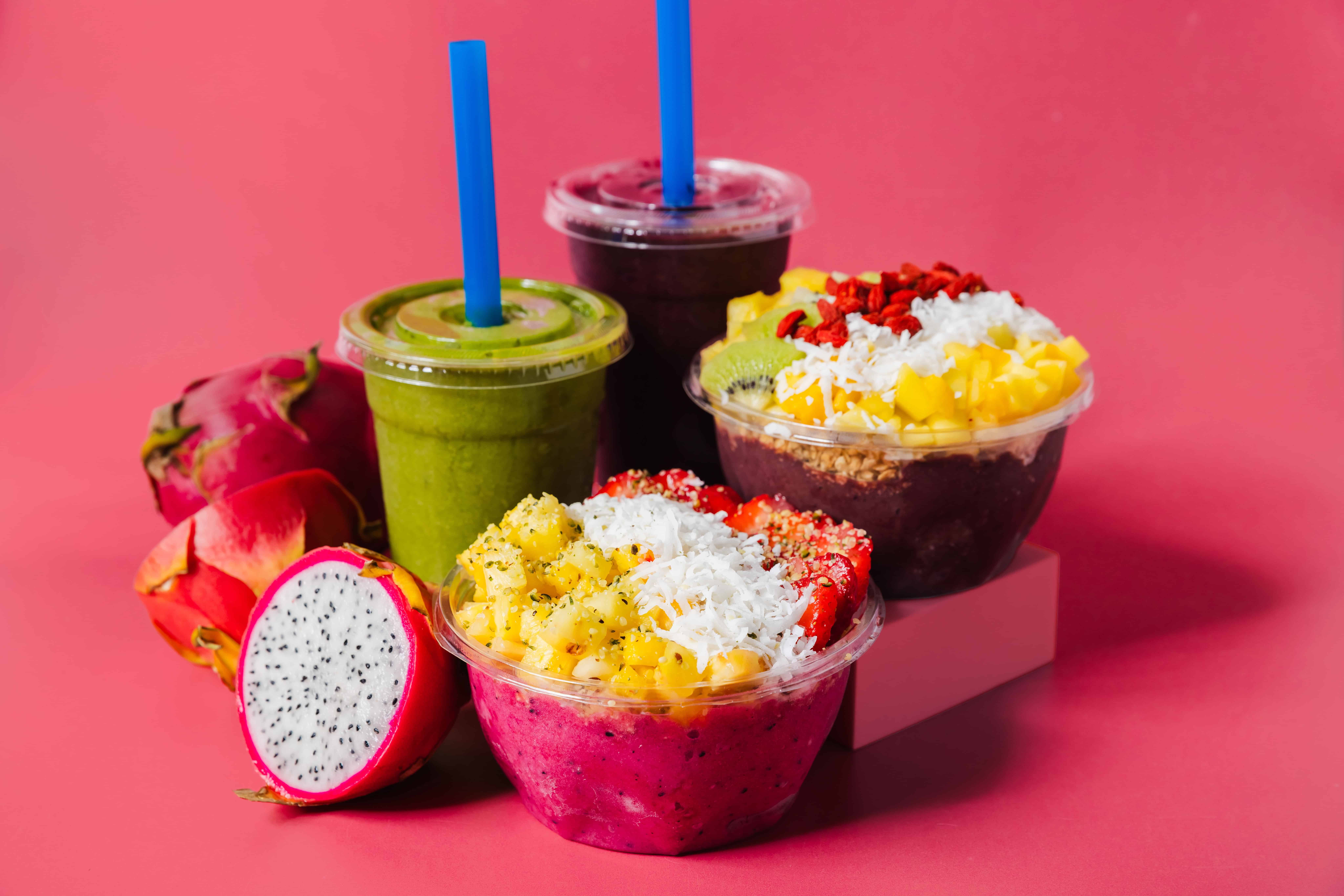 Palm Berries' açaí bowls and smoothies with ingredients with pink background.
