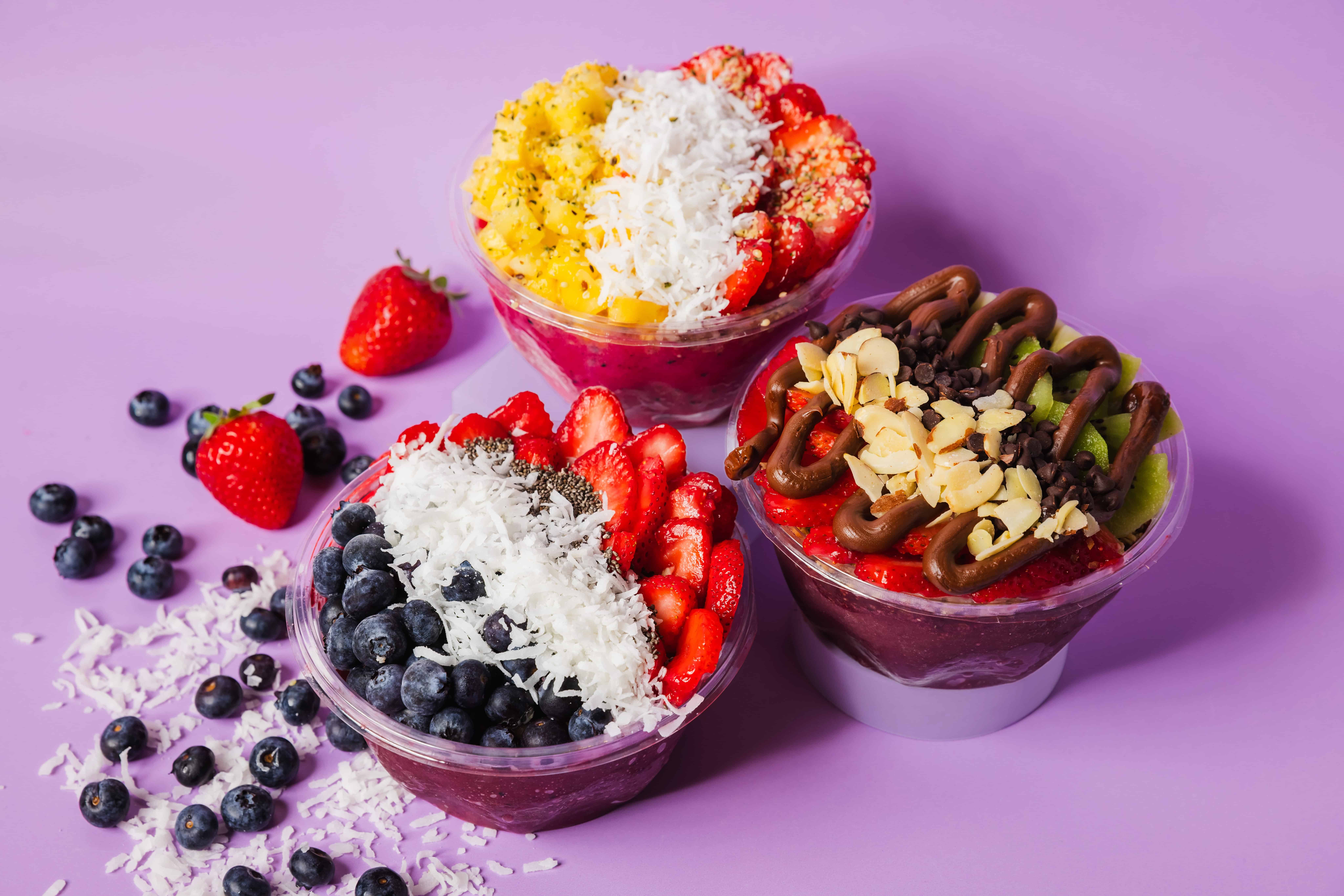 Palm Berries' delicious açaí bowls on purple background.